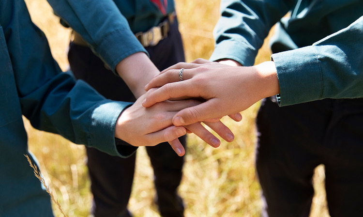 チームで手を重ねるスタッフ